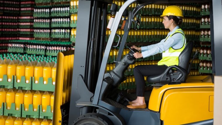 Kvinna som kör truck på lager